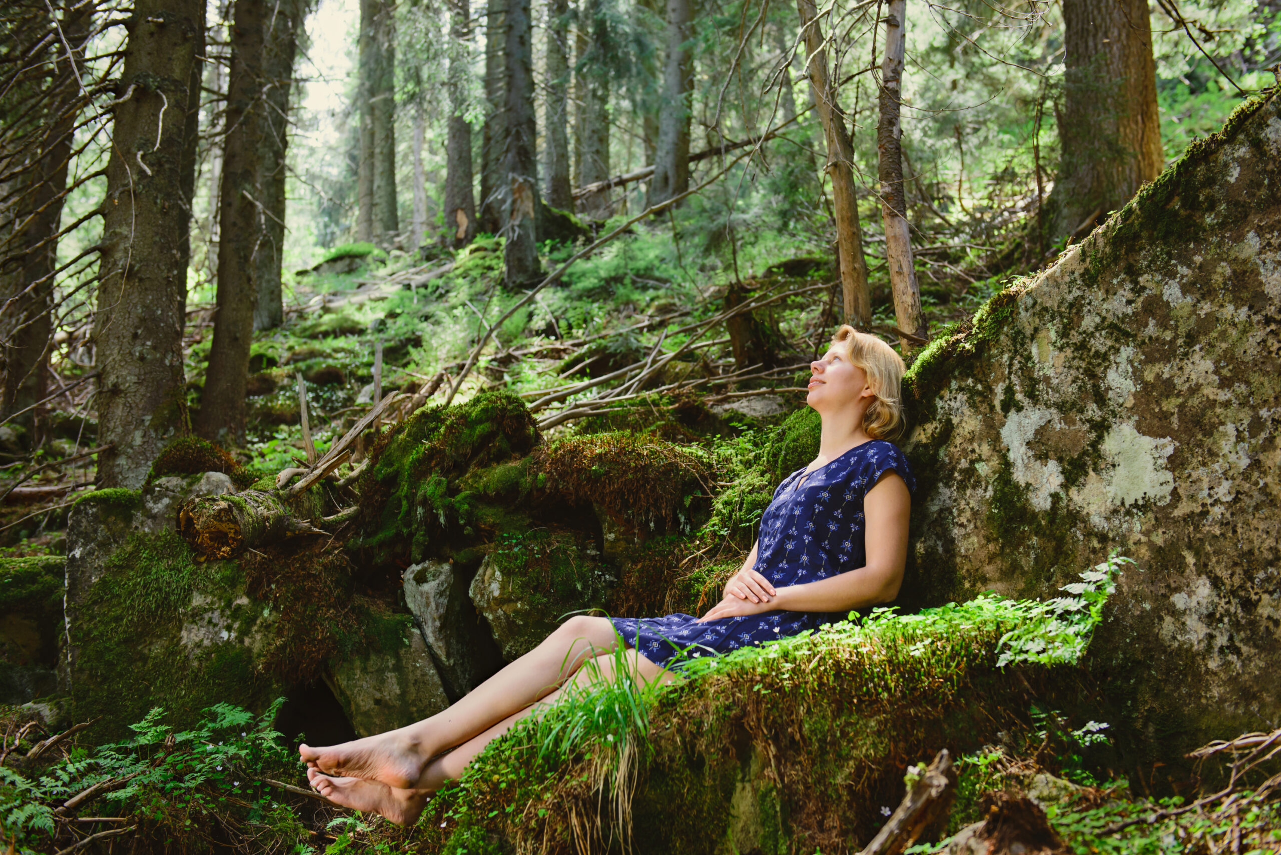 Woman sitting on the moss in the mountain mystery forest